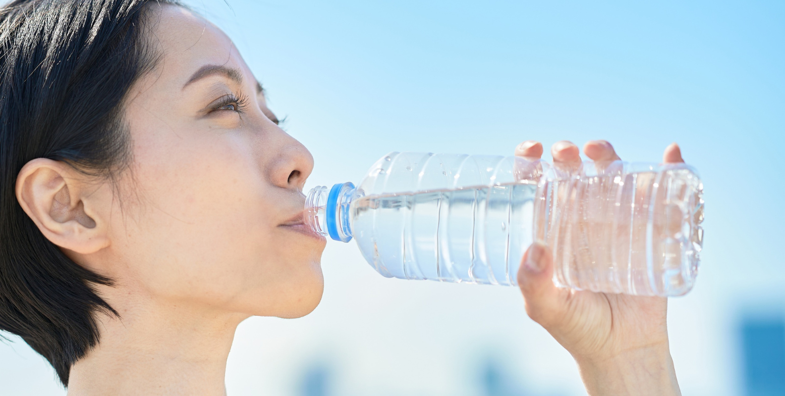 Eine Frau trinkt Wasser aus einer Flasche.