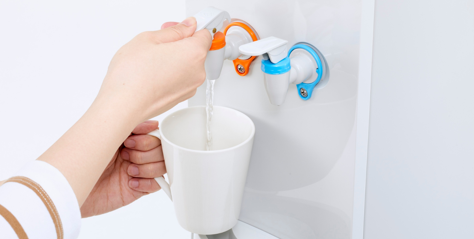 Eine Person bedient einen Wasserspender.