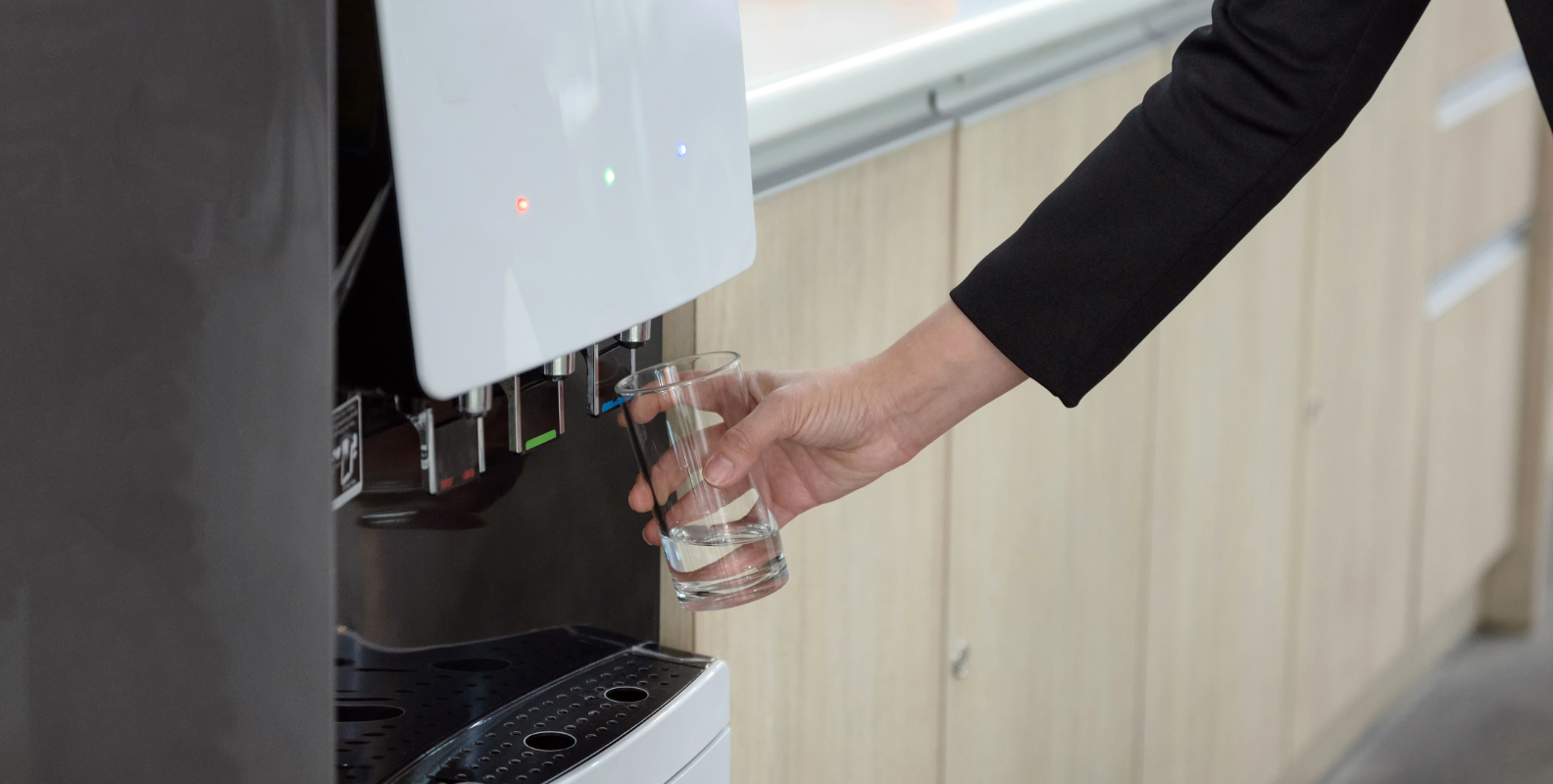 Eine Frau bedient einen Wasserspender
